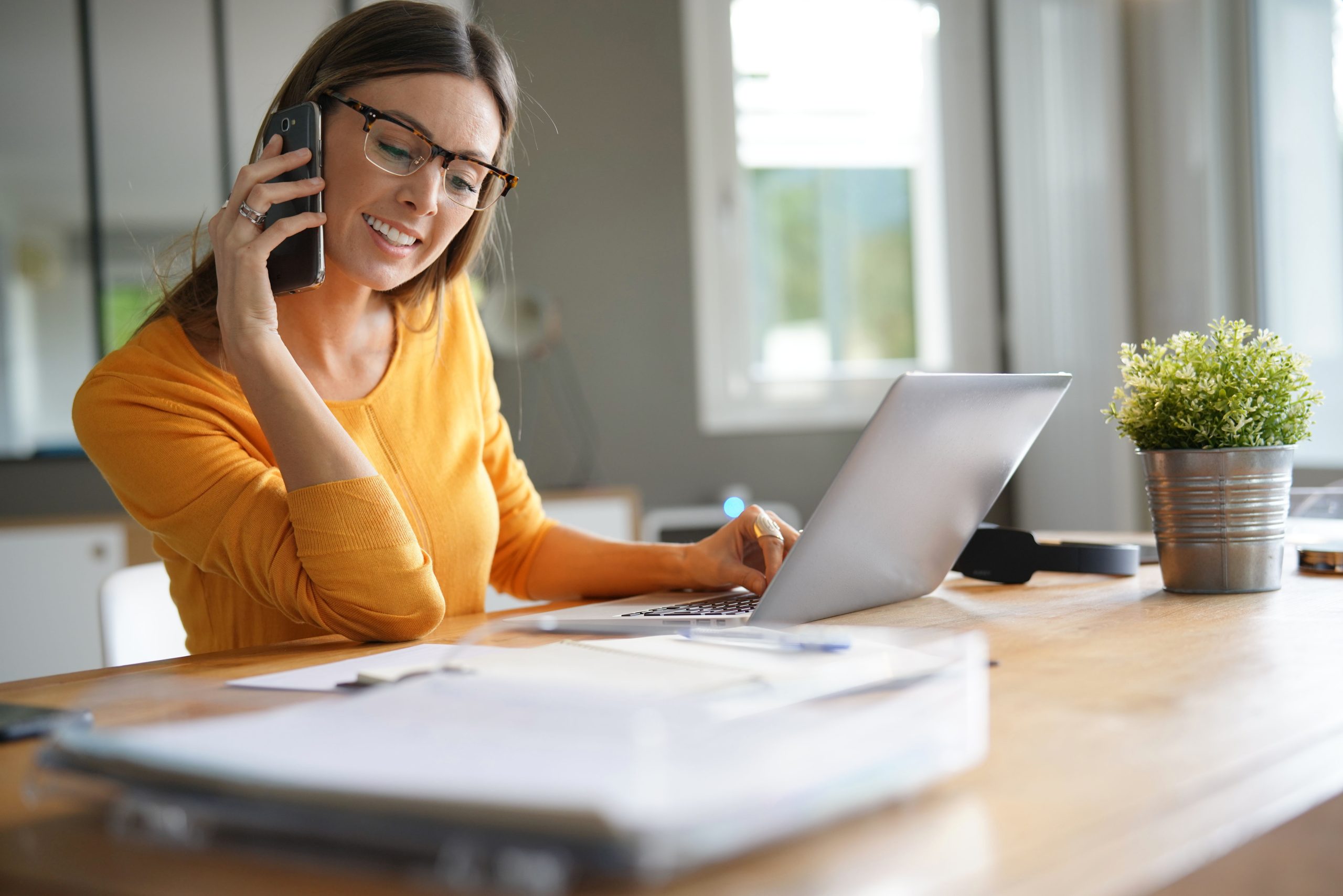 Woman in office talking on phone eFaktor scaled